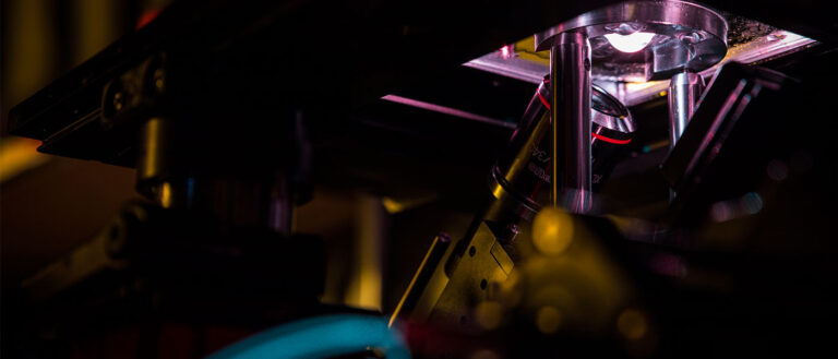 A photo of a 3D imaging machine, with purple light shining up through a tissue sample