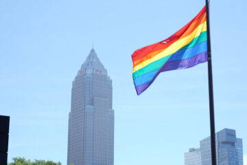 Photo of the Cleveland skyline with the LGBT Pride flag flying in the foreground