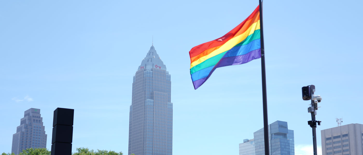 Photo of the Cleveland skyline with the LGBT Pride flag flying in the foreground