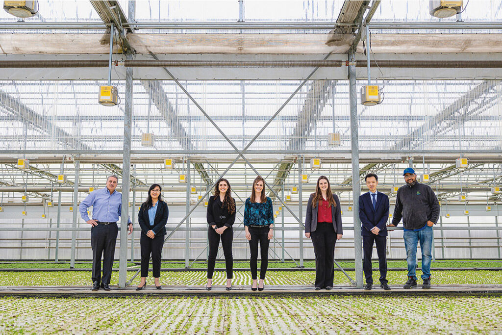 Photo of School of Law students and instructor standing in a line in a greenhouse