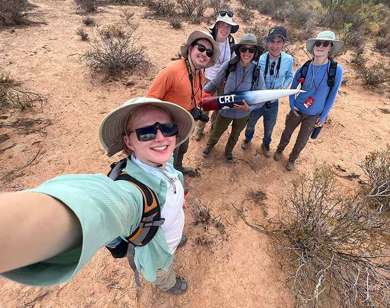 Photo of members of the Case Rocket Team taking a selfie and holding their rocket