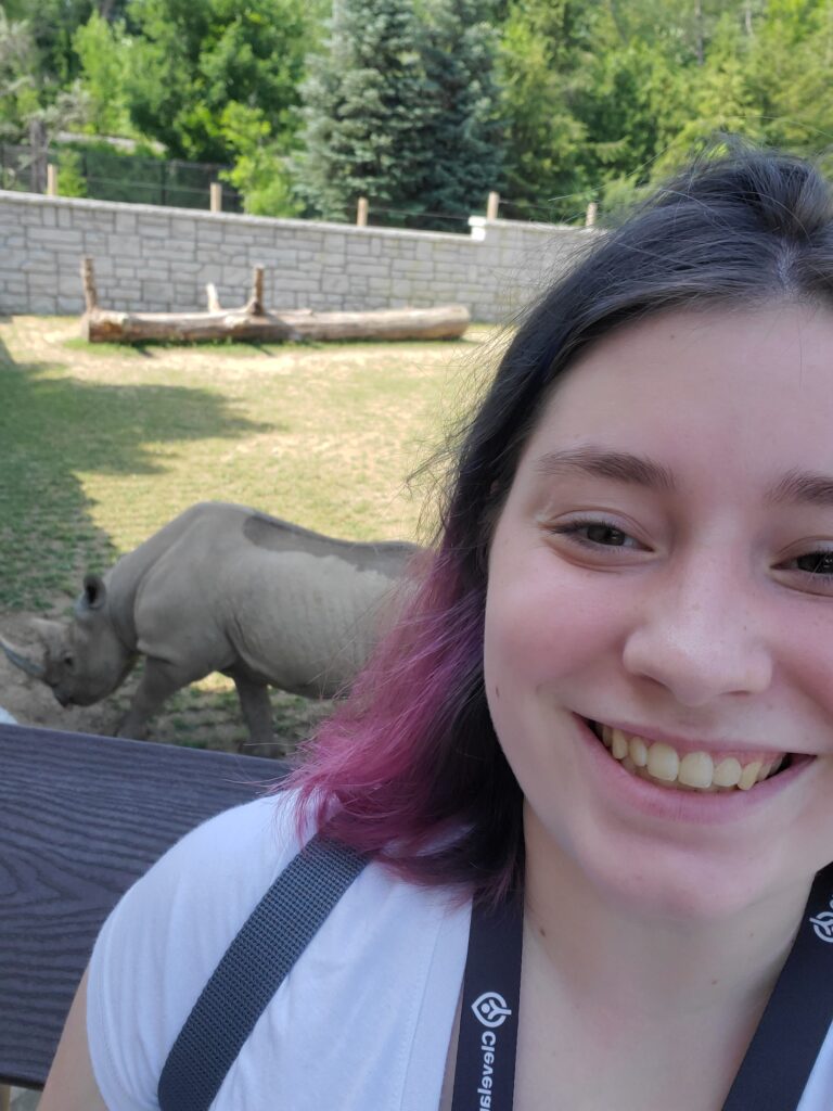 Photo of Aubrey Mayer with a rhino in the background