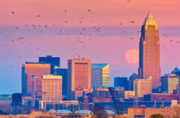 Photo of the Cleveland skyline with a supermoon in the purple-red hued sky