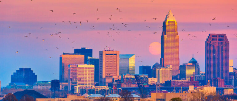 Photo of the Cleveland skyline with a supermoon in the purple-red hued sky