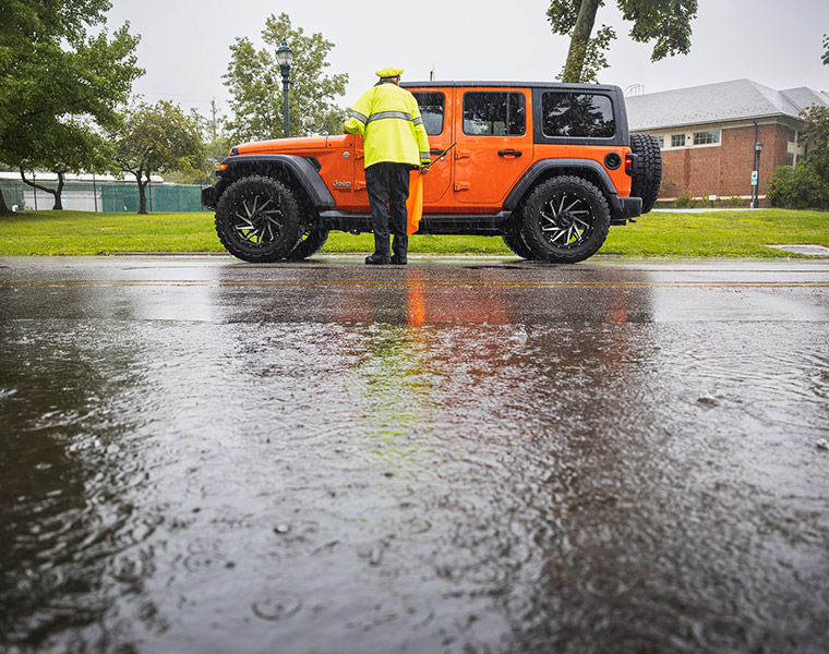 Traffic control officer talks to driver of orange jeep
