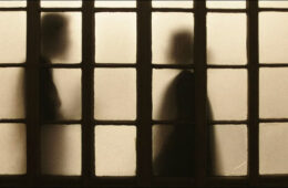 Two shadowy figures shown through windowpanes