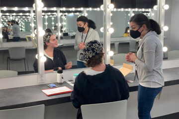 Female student prepares makeup in mirror