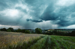 Photo of storm clouds above a grassy field