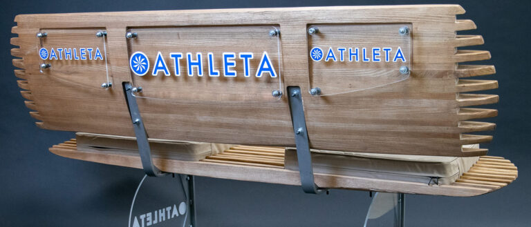 Photo of a tennis bench created by Jules Siegal with the Athleta logo on it
