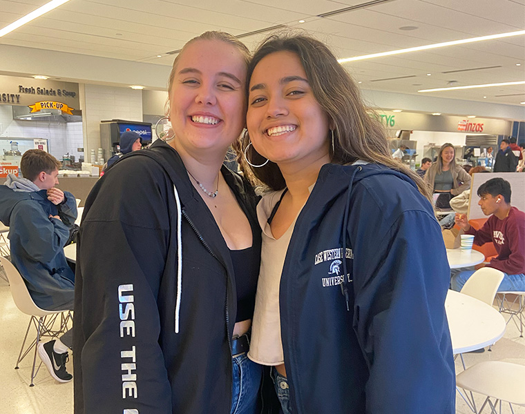 Paola Van der Linden and Nilany Rodriguez pose for a photo together inside Tinkham Veale University Center