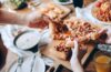 Close up of a group sharing pizza