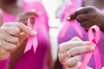 Photo of women holding up pink breast cancer awareness ribbons