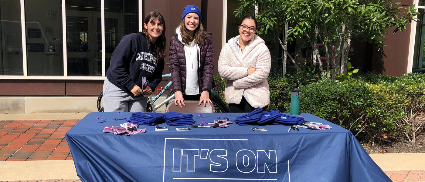 Photo of three individuals posing for a photo while tabling for It's on CWRU