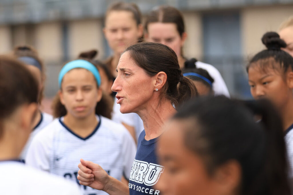 Photo of Abby Richter talking with a group of women's soccer players