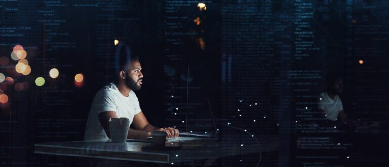 Shot of a programmer working on a computer code at night