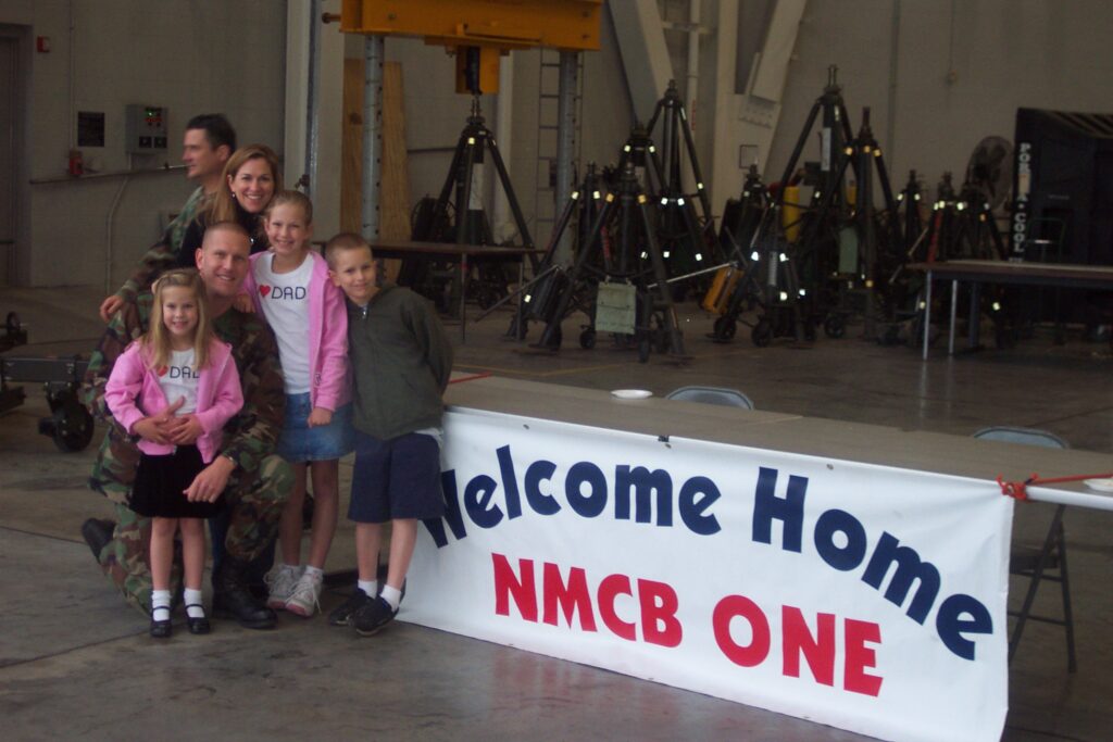Dean Tufts is welcomed back home by his wife, Anne, and three children, from Iraq in 2008. 