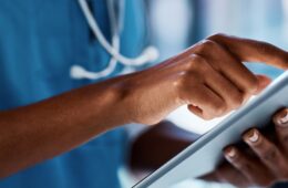 closeup of medical professional tapping a tablet.