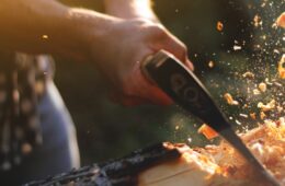 close up of lumberjack chopping wood with chips flying