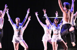 Photo of dancers with their arms up