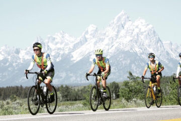 Photo of Steven Wang riding his bike with mountains in the background and three other cyclists with him