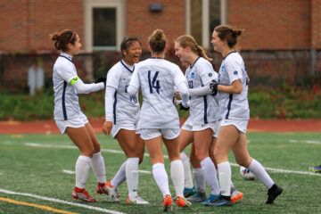 Photo of members of the CWRU women's soccer team coming together in celebration