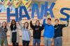 A group of students pose holding letters that spell out "THANKS"