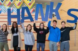 A group of students pose holding letters that spell out "THANKS"