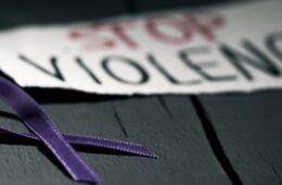 Close up of purple ribbon and sign that says "STOP VIOLENCE"