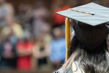 Photo from behind of a CWRU grad looking at the audience during commencement
