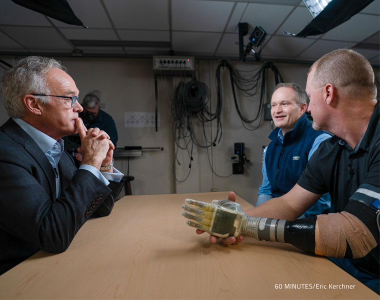 Photo of Dustin Tyler and a research participant talking with Scott Pelley