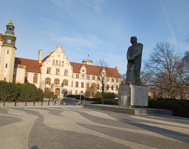 Photo of a university building and statue of the poet the university is named after, Adam Mickiewicz.