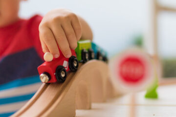 Close up photo on a child playing with a toy train