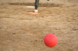 Close up of someone kicking a red ball