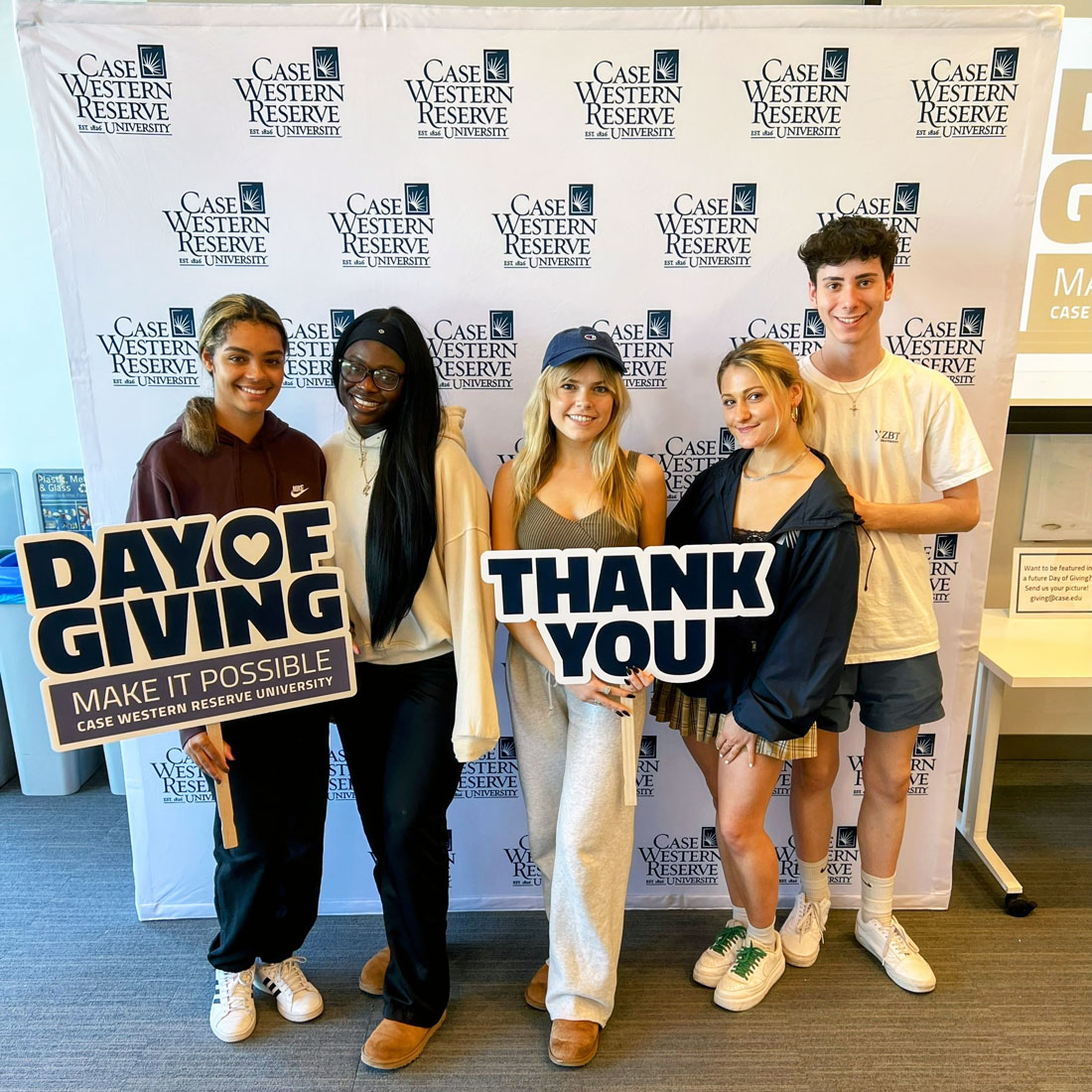 Photo of CWRU students posing for a photo with thank you and day of giving signs