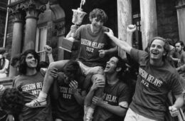 Photo of past Hudson Relays winners celebrating while holding a trophy
