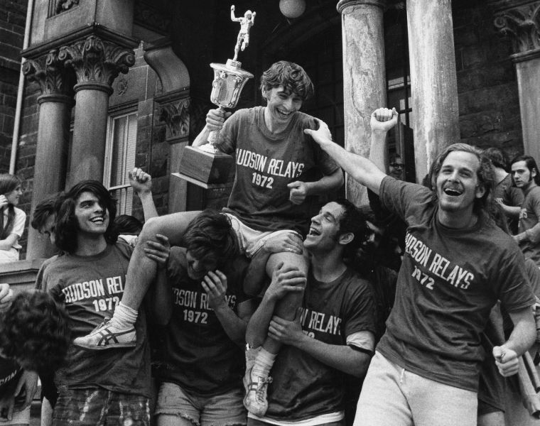 Photo of past Hudson Relays winners celebrating while holding a trophy