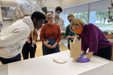 Photo of CWRU students working on the Art History Medieval Ivory HoloLens projects while CMA conservator Colleen Snyder holds triptych