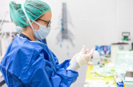 Photo of a nurse researcher putting on gloves in the lab