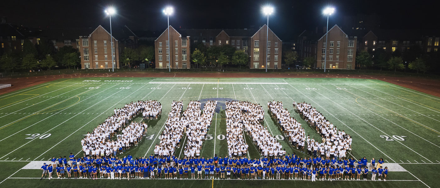 Photo of the Class of 2027 and orientation leaders on DiSanto Field forming the letters CWRU with an underline