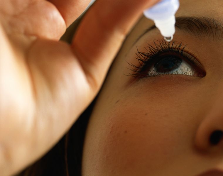 Close up of woman using eye drops