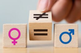 Concepts of gender equality. Hand flip wooden cube with symbol unequal change to equal sign