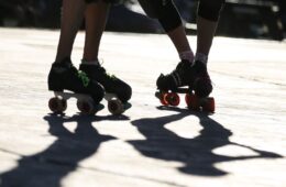 Shadows of the skates of several roller derby players.