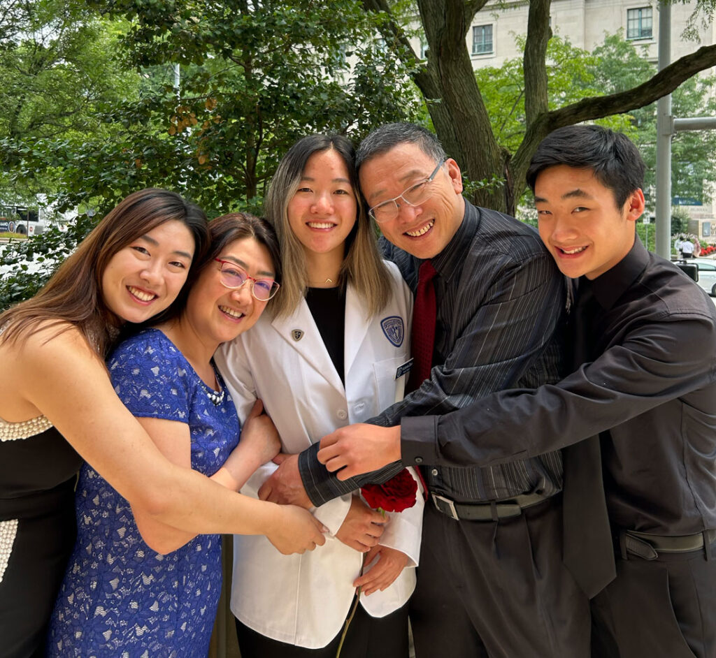Photo of Victoria Zhao in her white coat while with her family