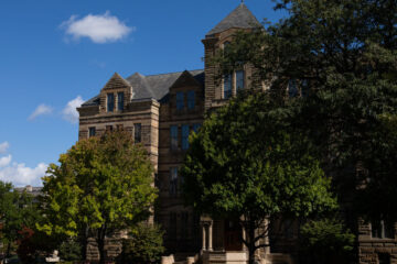 Photo of Adelbert Hall as a tree casts shadows on the building's Case Quad side