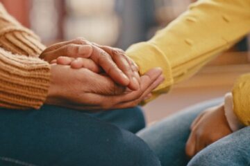 Hands, love and care touching in support, trust or unity for community, compassion or understanding. People holding hands in respect for loss, affection or passion for listening, talk or time