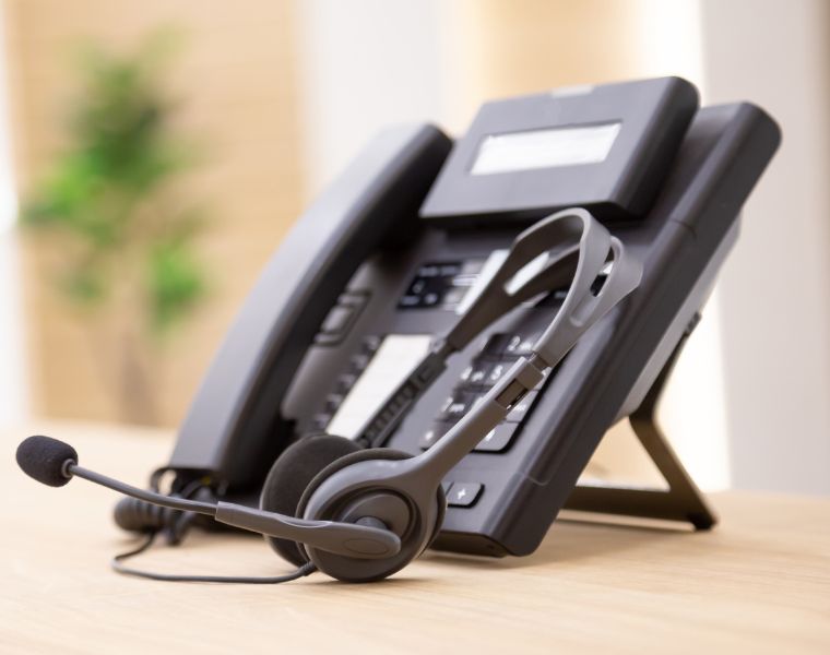 Photo of a call center phone with headsets.