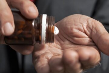 Elderly man with white pills