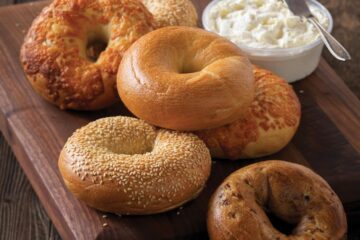 Photo of a half dozen variety of bagels with cream cheese.