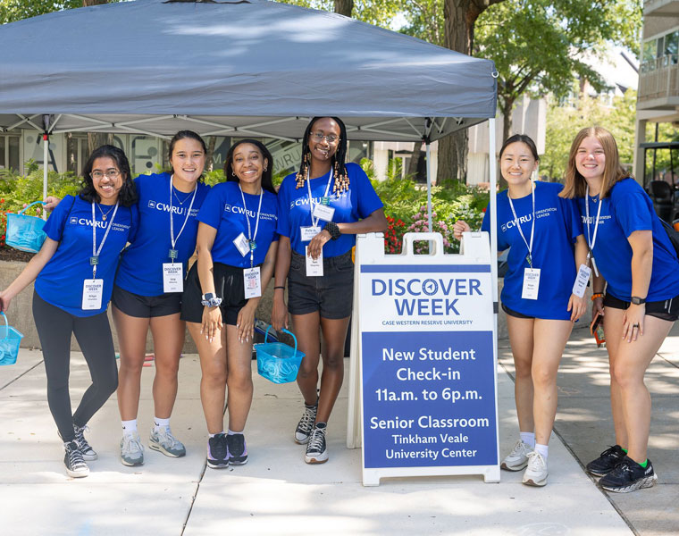 A group of Case Western Reserve University student orientation leaders pose near a Discover Week sign