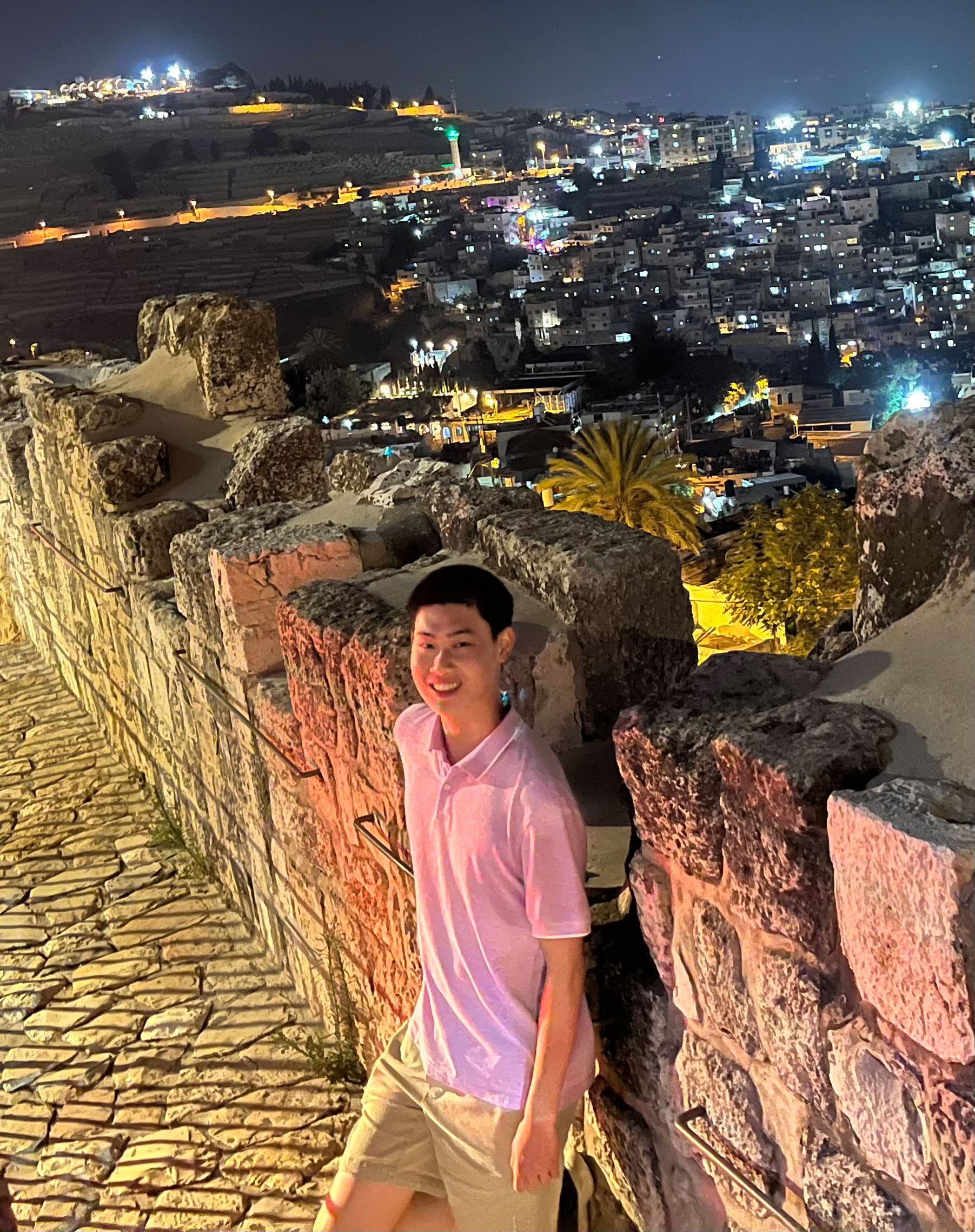 Photo of Jonathan Long on a balcony overlooking Old City in Jerusalem at night